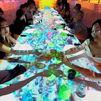 Guests seated at a projected dining table during a Hennessy VSOP event